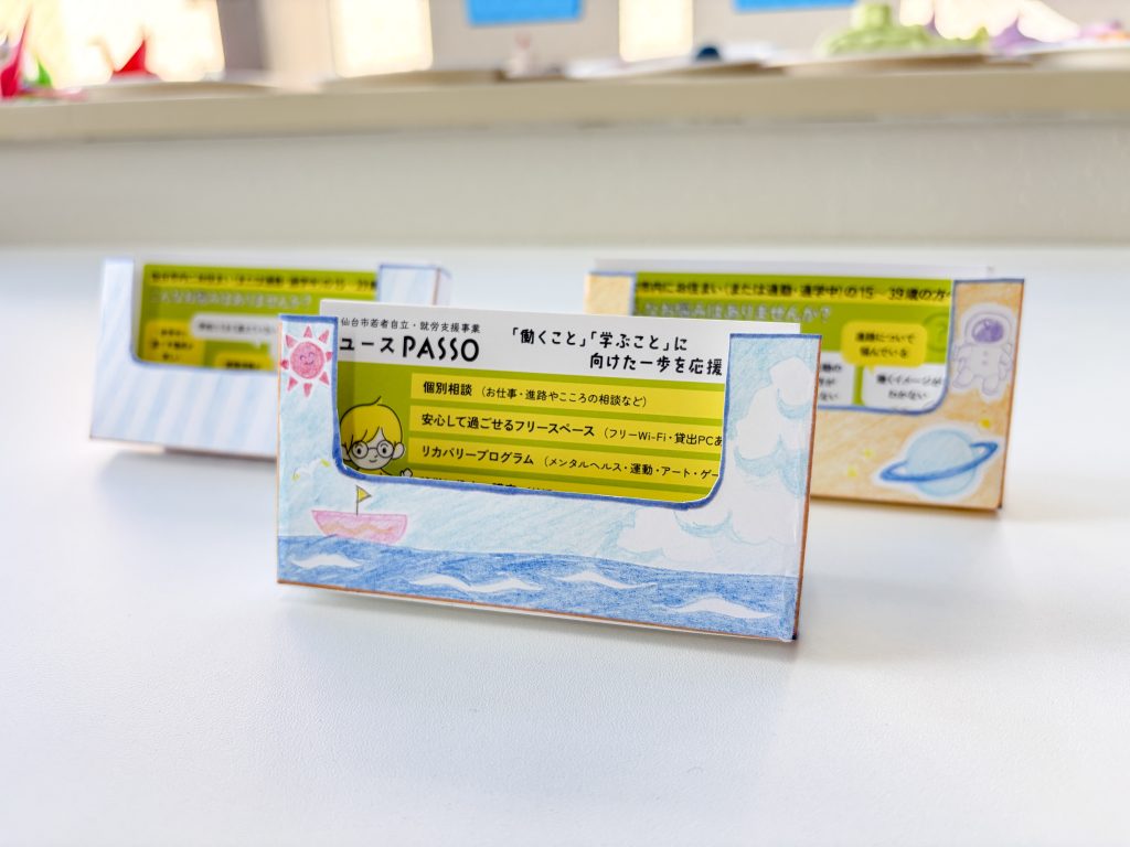ユースPASSOの事務補助実習で、参加者が画用紙を使って作成したカードホルダー。手作業を通して集中力や丁寧さを練習できる「働く準備」の時間。